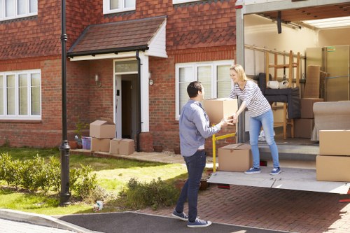 Professional furniture movers handling a sofa in Berrylands storage unit
